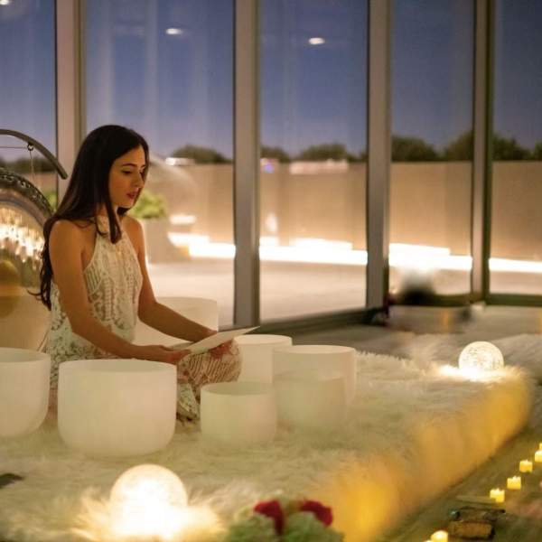 Person sitting on a blanket reading from a piece of paper