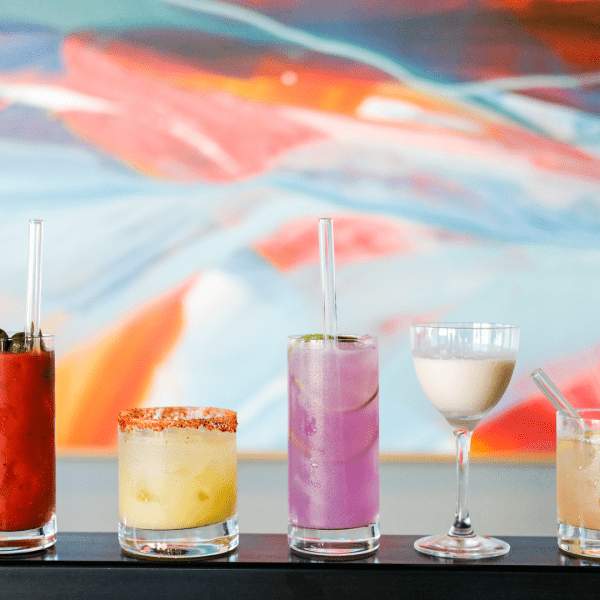 Una serie di cocktail colorati allineati in fila