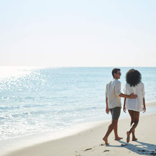 Two people walking on the beach