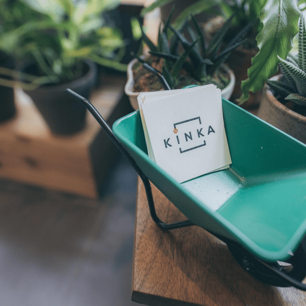 small cardholder in a pushcart shape with Kinka cards between small potted plants