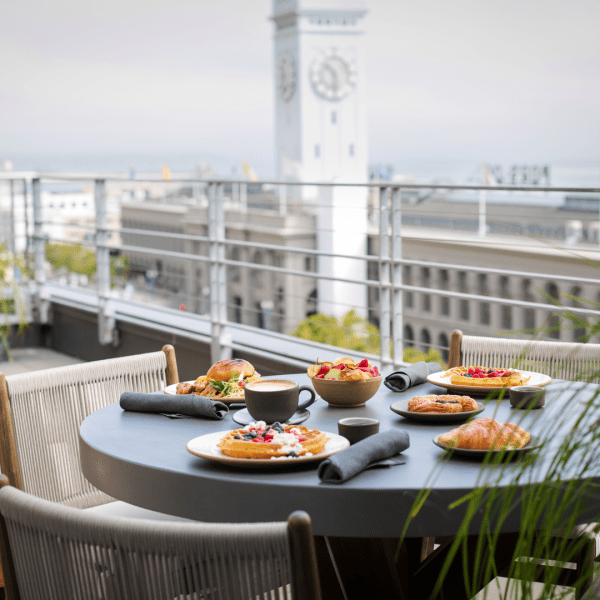 Breakfast served on a table set for three on the Terrace patio.  The San Francisco ferry building clock tower can be seen nearby.