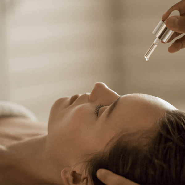 Person having moisture droplets applied to their forehead at a spa