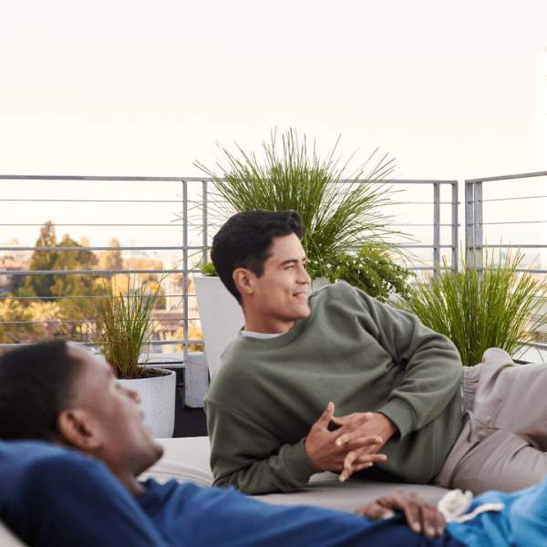 Deux hommes se prélassant dehors sur leur terrasse