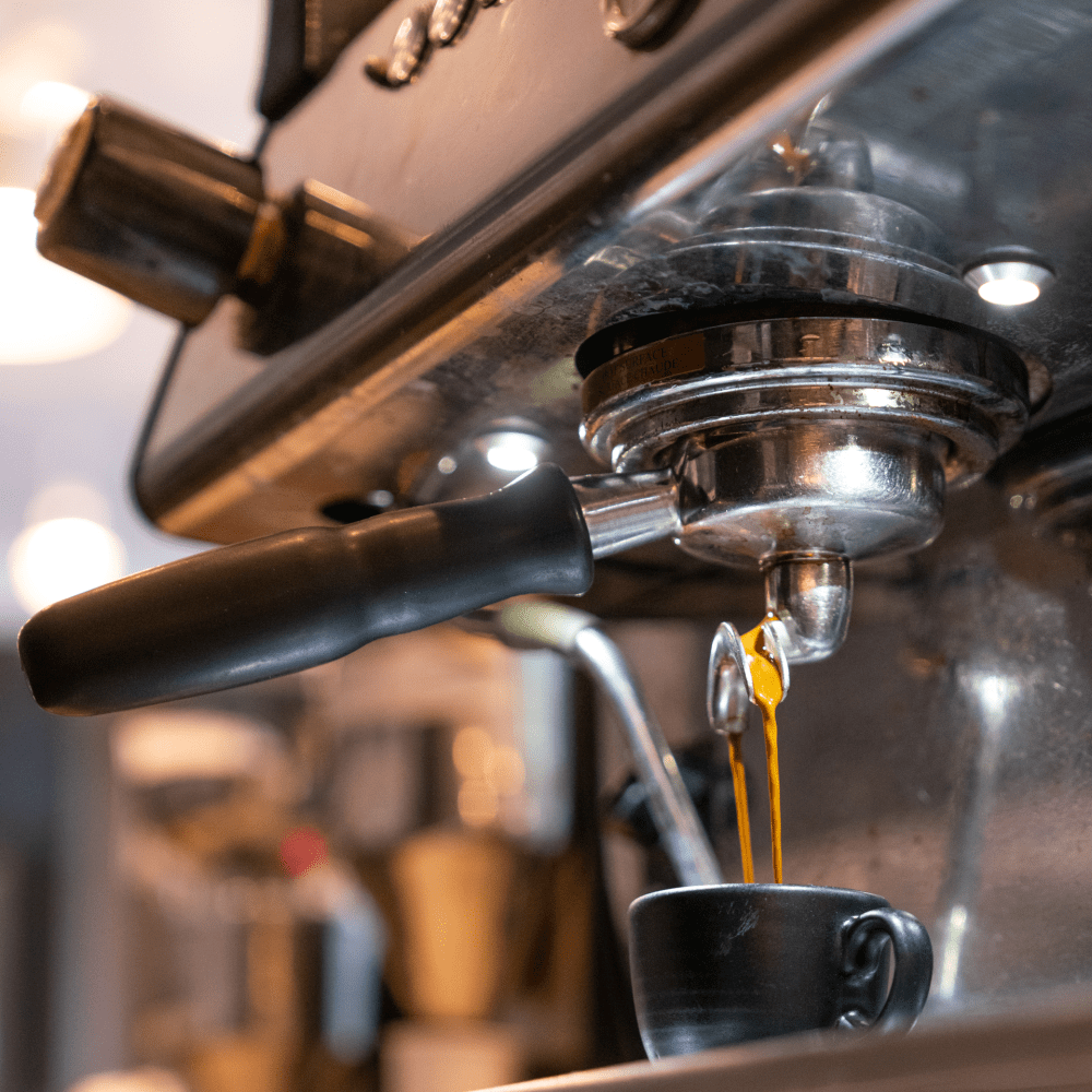 An up close shot of espresso being poured from an espresso machine