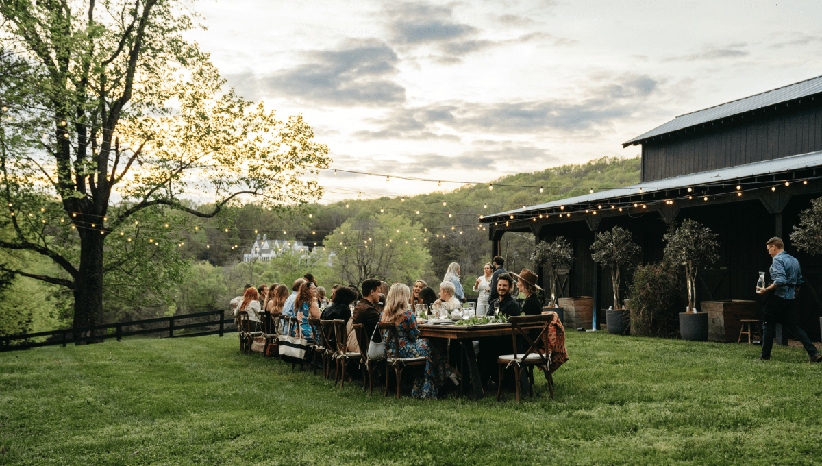 People sitting at a table outdoors on the grass