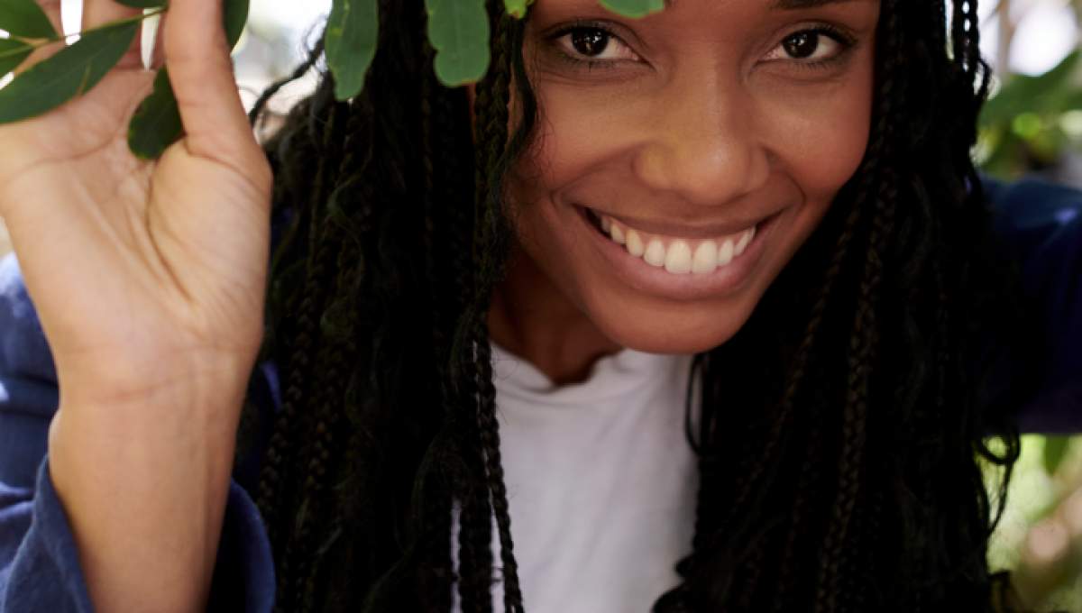 나뭇가지 뒤에서 웃고 있는 사람