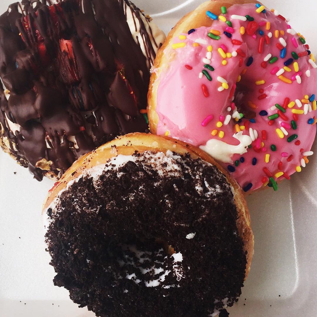 A close up of three different artisinal doughnuts