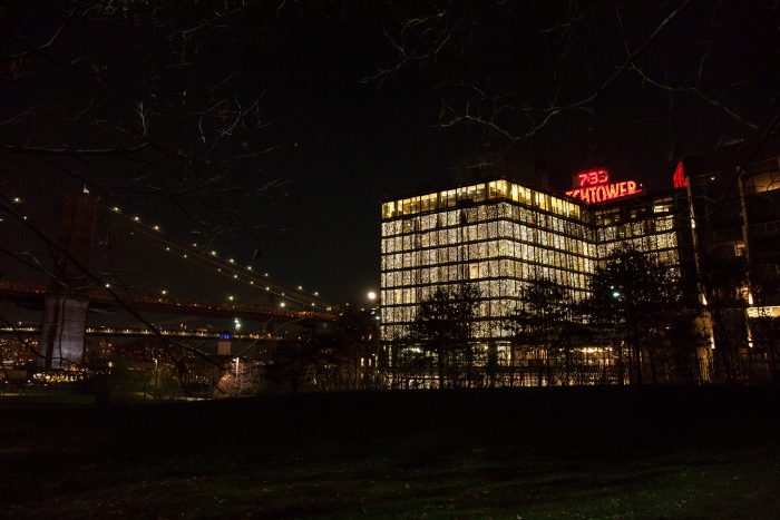 The exterior of 1 Hotel Brooklyn Bridge lit up at night