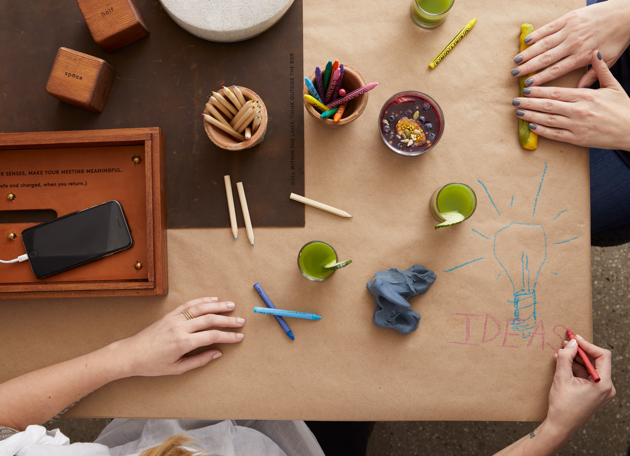 Two women at a crafting table with crayons and sculpting putty.