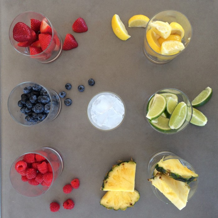 Several glass cups filled with different smoothie ingredients