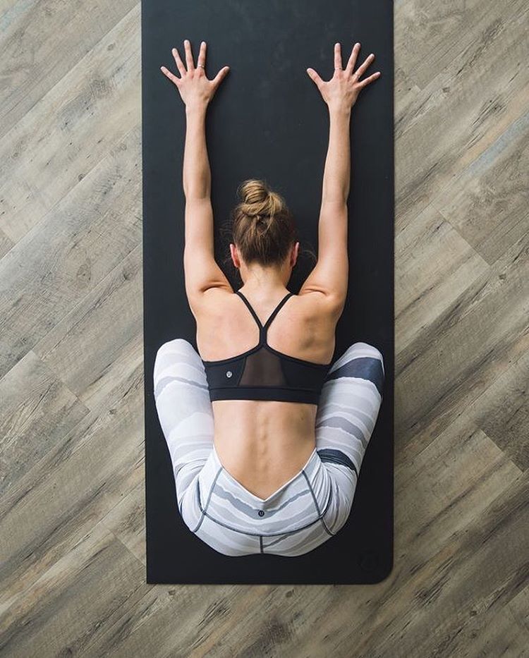 An aerial view of a woman on a yoga mat in child's pose