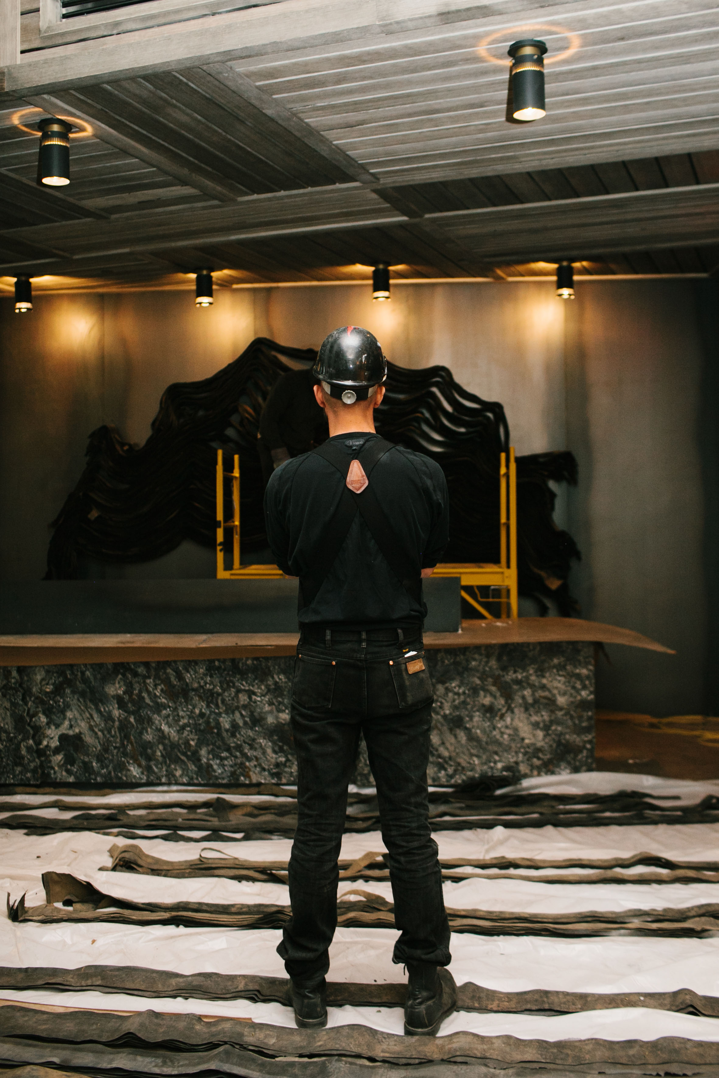 Jarrod Beck standing in front of his art installation with his back to the camera