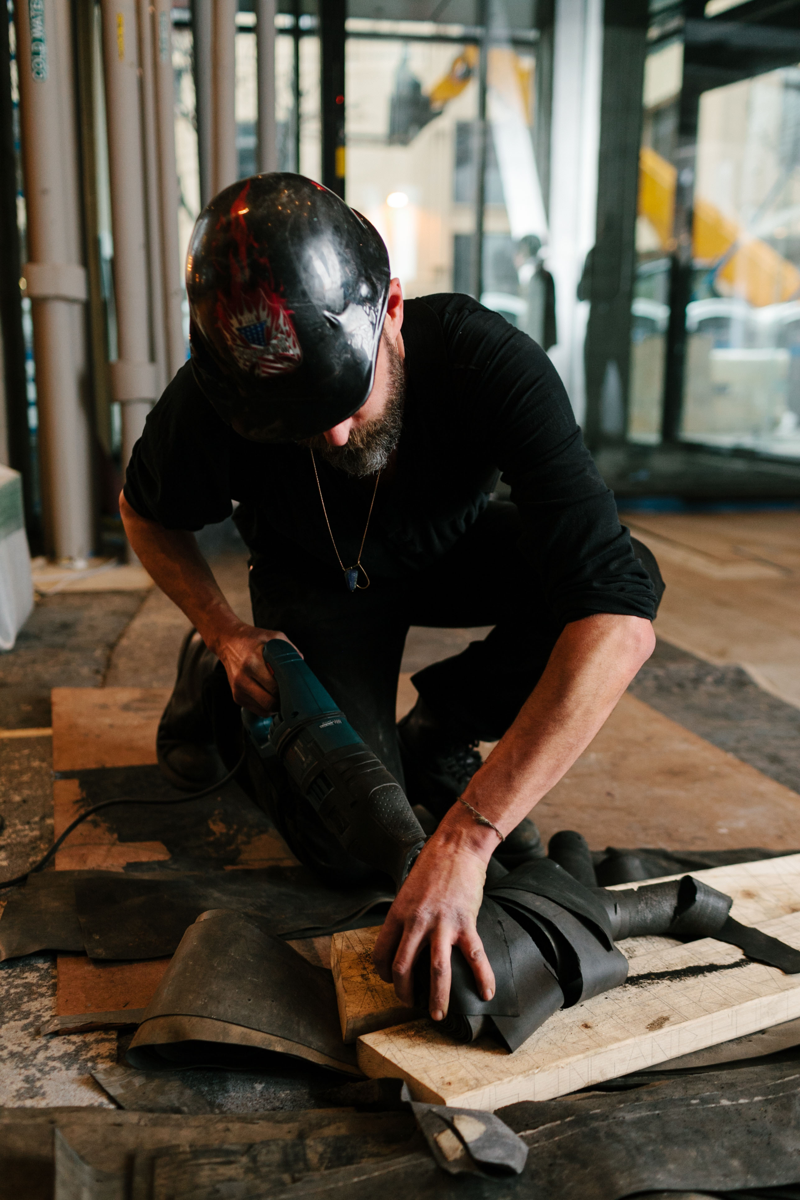 Jarrod Beck constructing his art installation with wood and rubber