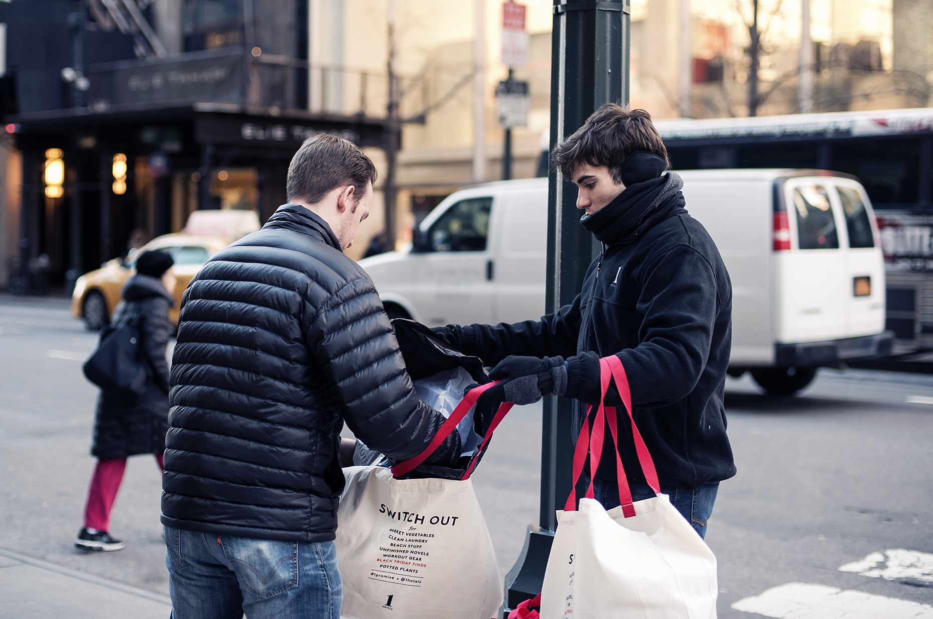 2 young men using 1 Hotels reusable tote bags