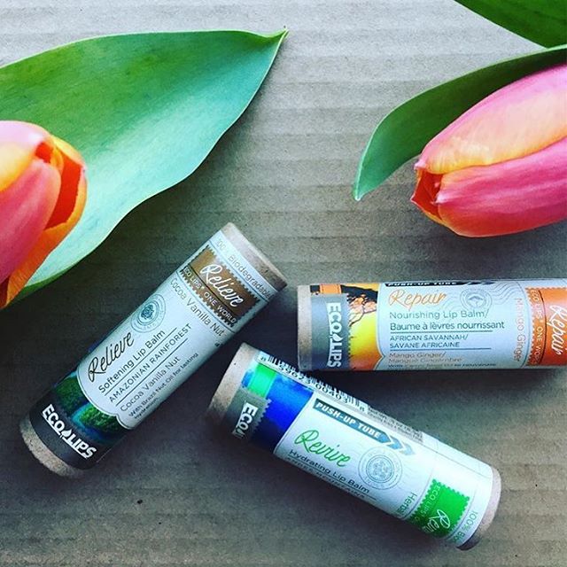Three tubes of Repair lip balm surrounded by tulips