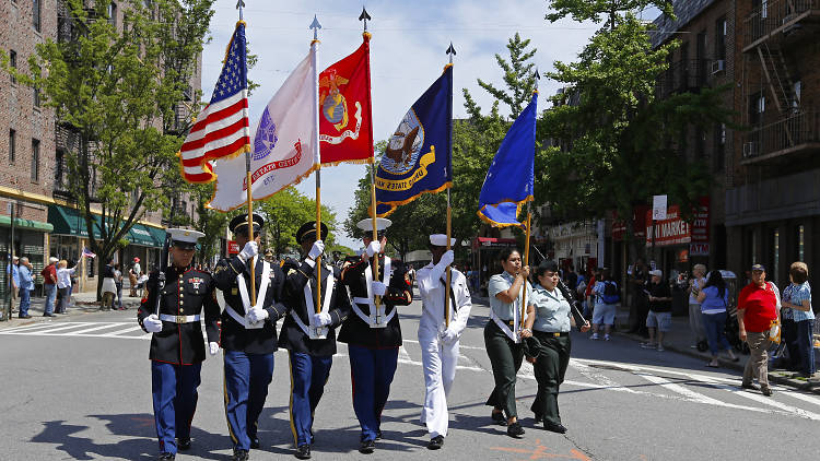 People marching in uniform holding different flags