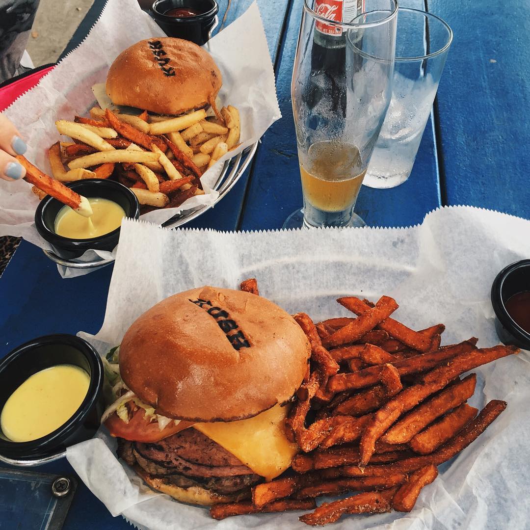 Two baskets with cheeseburgers, fries, and sweet potato fries