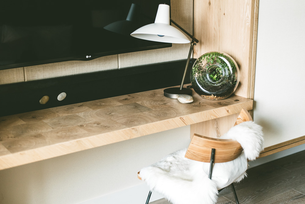 A wooden desk and chair in a hotel suite