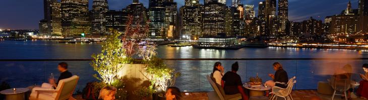 The Rooftop at 1 Hotel Brooklyn Bridge at night with view of Manhattan skyline