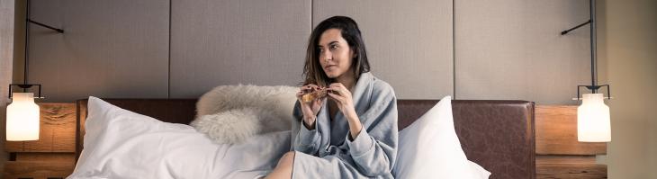 Woman in bed with coffee in bathrobe