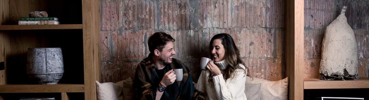 Couple on couch drinking coffee