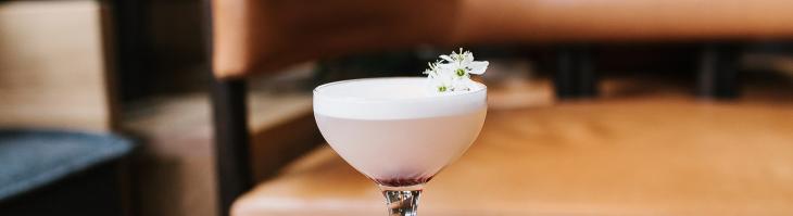fancy pink cocktail with flower in cupe glass