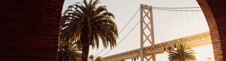 The Golden Gate bridge, visible through a brick archway