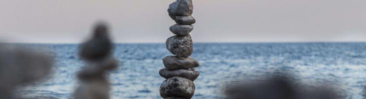 Rocks stacked atop one another in front of the ocean