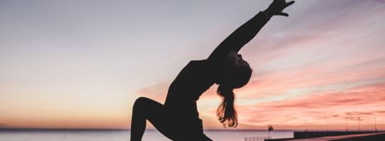 Woman doing yoga during sunset or full moon 