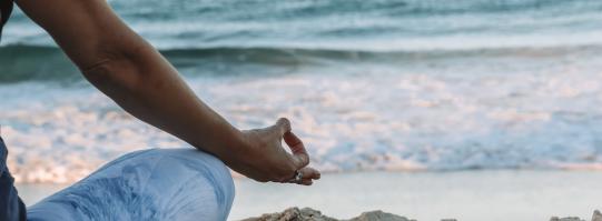 woman sitting on the beach doing yoga pose