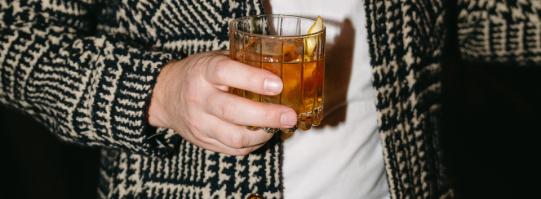 man holding whiskey glass