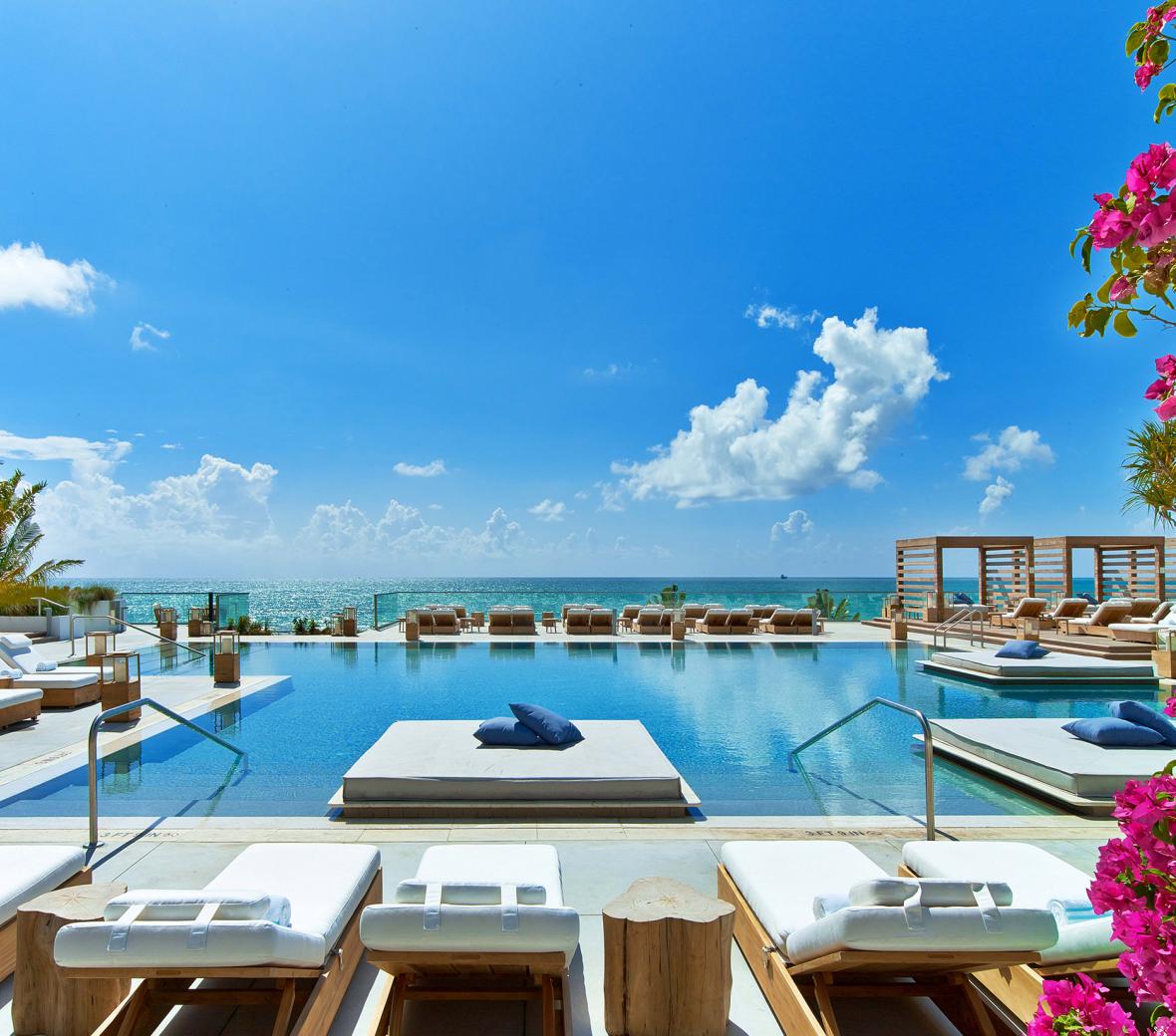 South Beach pool surrounded by cabanas and day loungers