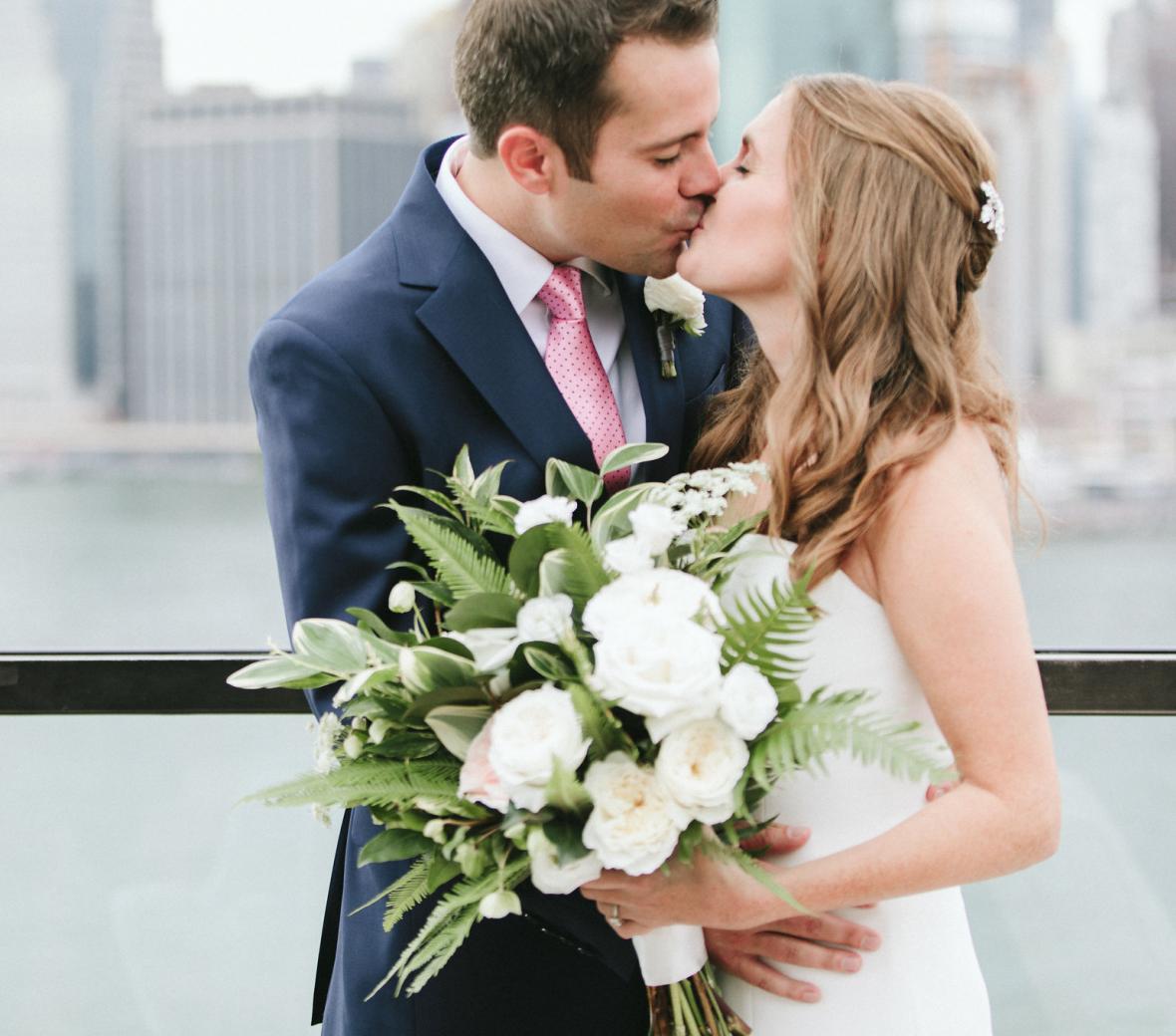 Couple kiss in front of Brooklyn Bridge