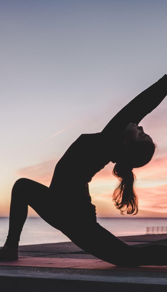 Woman doing yoga during sunset or full moon 