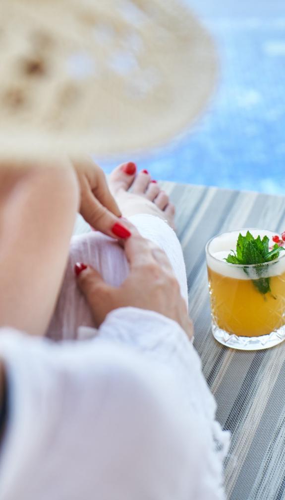 woman with cocktail by the pool