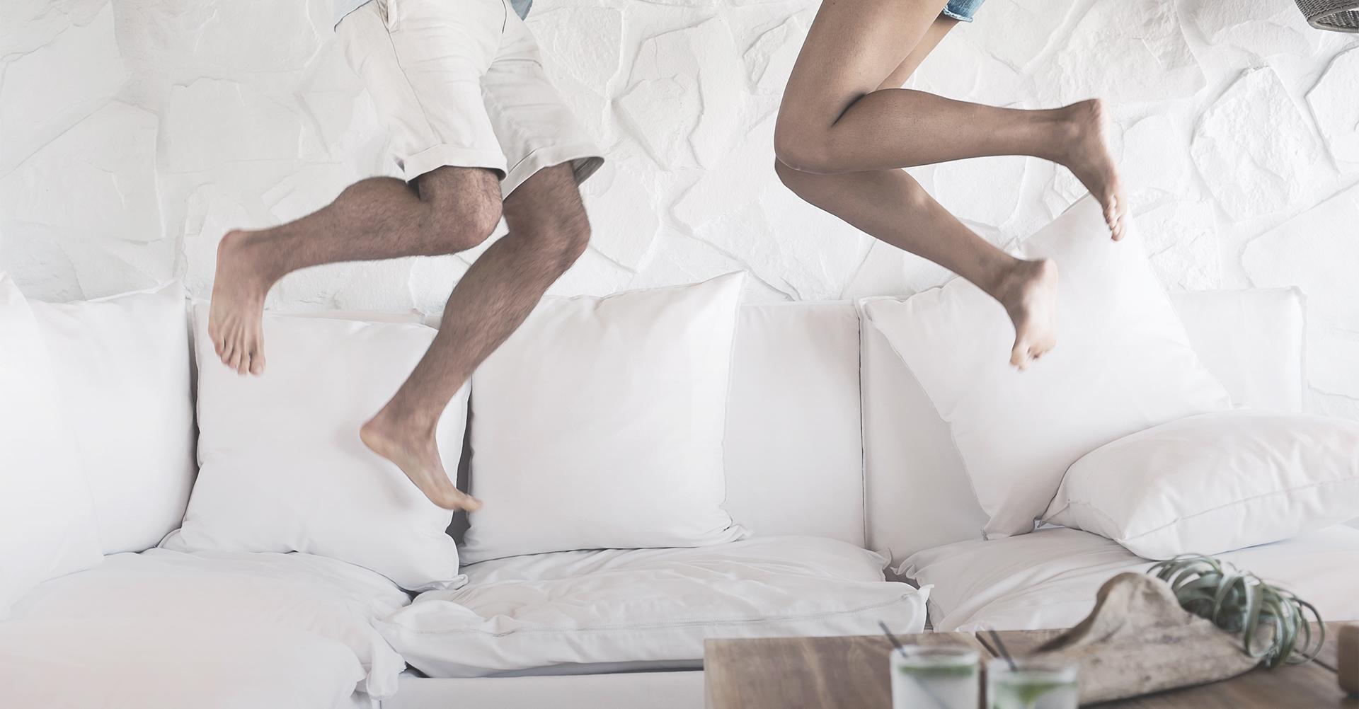 A couple jumping on the bed