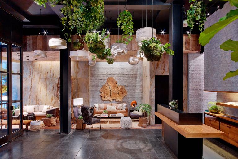 The lobby of 1 Hotel Central Park, furnished with wood and greenery