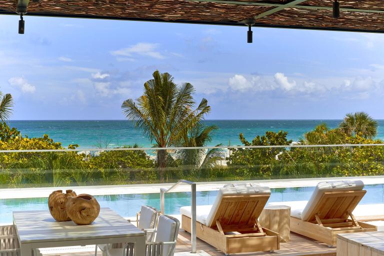 cabanas next to a pool with view of the ocean