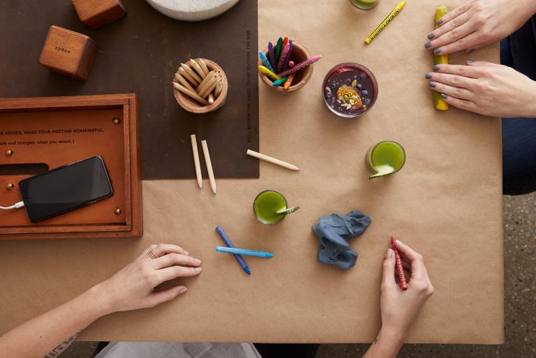A table with pencils, clay, and other creative materials